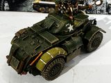 a toy army vehicle on a table next to a picture of soldiers