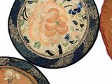 three plates with floral designs are sitting on a white surface
