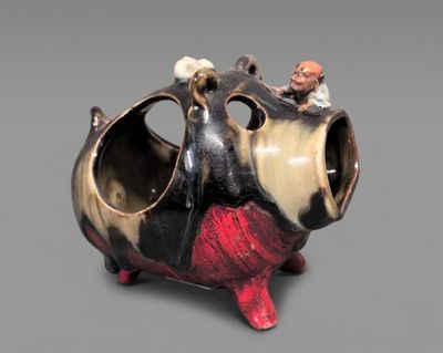 a small figurine of a cow with a man sitting on top of it