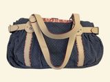 a blue purse with a tan strap on it