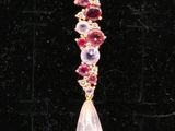 un gros plan sur une paire de boucles d'oreilles roses et violettes posées sur une surface noire