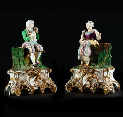 deux figurines représentant un homme et une femme assis sur une souche d'arbre