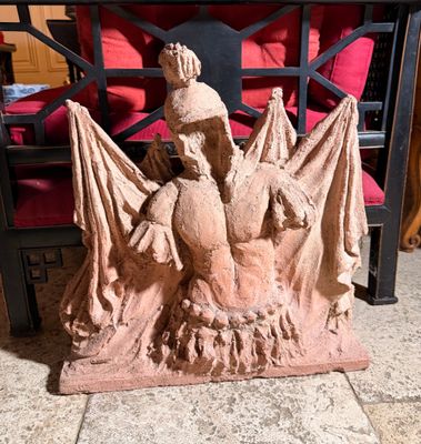 une statue représentant un homme assis sur une chaise, tenant une batte