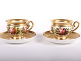 deux tasses et soucoupes ornées de bordures dorées et de motifs floraux