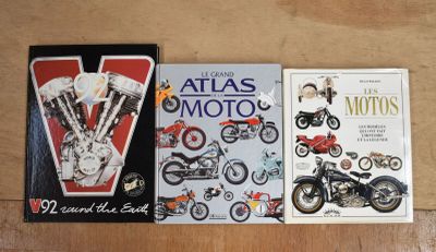 deux livres posés sur une table, à côté d'une moto et d'un atlas consacré à la moto