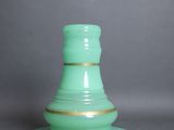 un vase vert posé sur une soucoupe