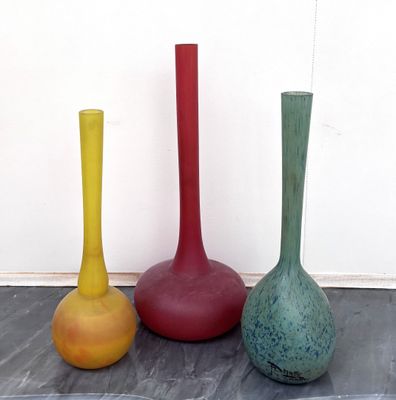 trois vases de couleurs différentes posés par terre