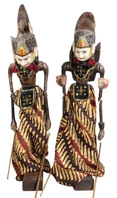 deux figurines représentant deux femmes vêtues de costumes traditionnels et tenant des cannes