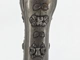 a silver vase that is sitting on a table