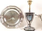 two silver dishes and a silver cup on a table