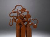 a sculpture of a tree made of metal on top of a piece of wood