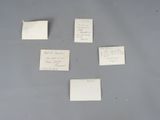 four pieces of paper with writing on them sitting on a table