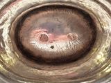 a close up of a silver bowl on a table