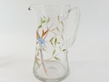 a glass pitcher with a bird painted on it
