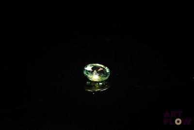 gros plan d'un diamant vert sur une surface noire