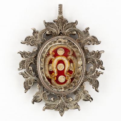 an image of a silver and red broochle on a white background