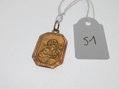 une petite médaille en or sur laquelle est représentée une femme