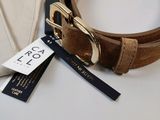 a brown belt with a gold buckle next to a bag