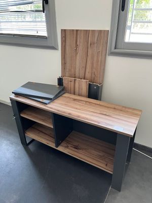 un bureau en bois sur lequel est posé un ordinateur portable, dans une pièce