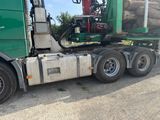 un gros camion avec un important chargement de grumes à l'arrière