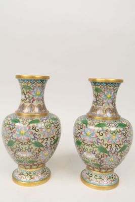 une paire de vases posés sur une surface blanche, sur fond blanc