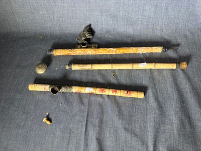 Trois vieilles battes de baseball sont posées sur un tissu bleu.
