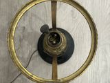 an antique brass clock with a circular face on a wooden surface