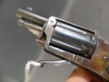 a person holding a small revolver in their hand
