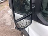 a side view mirror of a truck with a dog in it