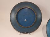 two blue plates with gold rims on a table