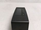 a black remote control sitting on a white surface