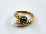 a close up of a gold ring with a pearl on it