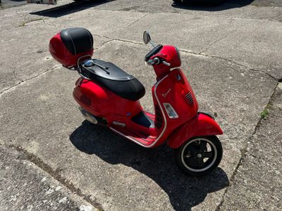 a red scooter that is parked in the parking lot