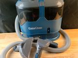 un aspirateur posé sur une table, muni d'un tuyau
