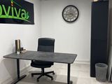 un bureau avec une chaise et une horloge accrochée au mur