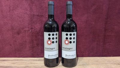two bottles of wine sitting on top of a wooden table