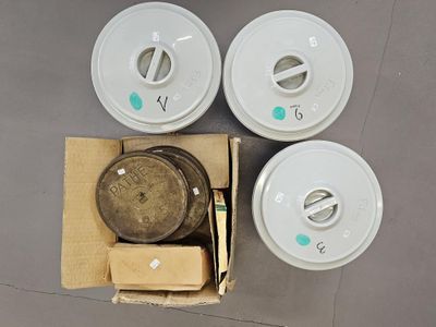 quatre gobelets en plastique blancs posés sur une boîte en carton, à côté d'une autre boîte en carton