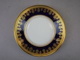 a gold and blue plate sitting on a white table