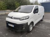 une camionnette Citroën garée sur un parking devant un immeuble