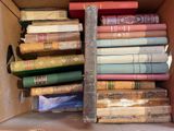 une boîte pleine de vieux livres posée sur le sol