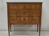 a small wooden chest of drawers with a marble top