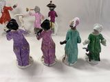 five figurines of people dressed in different colors
