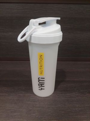 un shaker blanc avec un couvercle blanc posé sur une table en bois