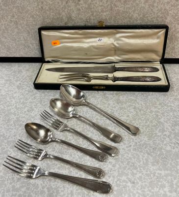 cinq fourchettes et cuillères dans un coffret posé sur la table