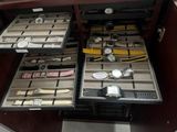many watches and watches in a case on the table