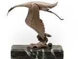 statue d'un oiseau posée sur un socle en marbre, sur fond blanc