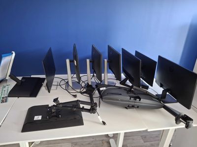 four computer monitors sitting on a desk with a laptop on it