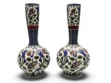 une paire de vases ornés de motifs floraux sur un fond blanc