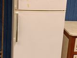 a white refrigerator sitting in the middle of a room