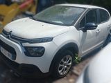 a small white car parked on the side of the road